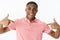 Close-up shot of self-satisfied confident good-looking african american cheerful guy in pink polo shirt pointing at