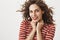 Close-up shot of sensual feminine woman in red lipstick and striped sweater, standing in tender and cute pose, holding