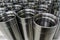 A close-up shot of shiny steel aerospace cnc turned tubes in a batch with selective focus and background blur