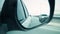 Close-up shot of a side rear view mirror of car. Stock. Side view mirror view of cars driving behind on a highway
