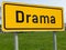 CLOSE UP: Shot of signpost showing traffic they are arriving into Drama village.