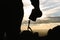 Close up shot silhouette young man photographer hiking and holding camera standing on the mountain peak