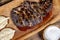 Close up shot of sliced roasted liver on wooden platter, next to garlic sauce