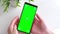 Close-up shot of a smartphone with green screen on in man\\\'s hand.