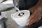 Close up shot of someone making delicious creamy coffee in a white mug