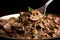 close-up shot of a spoonful of beef stroganoff showing the beef, mushrooms, and creamy gravy