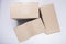  close up shot of three stacked closed rectangular blank brown carton cardboard boxes on a white background