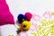 Close up shot of three woolen pom pom of pink, yellow and blue attached with a key chain