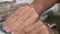 Close up shot of two hands sanding the edge of a very worn window frame with paint chips peeling off in slow motion