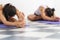 Close up shot of two women doing yoga while stretching with Janu Sirsasana pose