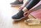 Close up shot view of fit woman tie shoelaces while doing workout at home. Bottle of water. Athletic female tying the laces on