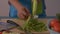 Close up shot of woman hands peeling angled loofah on wooden cutting board for healthy food on the table.