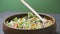 Close up shot of a woman holding a plate of fresh green salad in the beautiful morning light. She`s holding a fork and