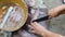 Close up shot of a woman`s hand cleaning and cutting fish on a wooden board.