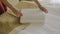 Close-up shot, a woman`s hands, professionally putting two fresh clean towels on a bed with a white sheet.