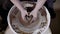 Close up shot of the woman`s hands, the student tries to create a clay pot in the workshop for pottery courses