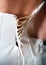 Close-up shot of woman in white corset rear view