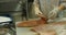 Close-up shot of a woman worker\'s hand in a market factory, a woman stands on the process of cutting a salmon and