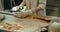 Close-up shot of a woman worker\'s hand in a market factory, a woman stands on the process of cutting a salmon and