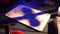 Close up shot of a wooden ouija board with a planchette on a table surrounded by candles, candlesticks and other