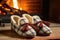 close-up shot of woolen slippers by a roaring fireplace