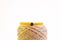 Close-up shot of a yellow handmade bracelet on a burlap thread isolated on a white background