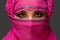 Close-up shot of a young charming woman wearing the pink hijab decorated with sequins. Arabic style.