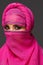 Close-up shot of a young charming woman wearing the pink hijab decorated with sequins. Arabic style.