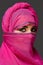 Close-up shot of a young charming woman wearing the pink hijab decorated with sequins. Arabic style.