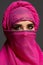 Close-up shot of a young charming woman wearing the pink hijab decorated with sequins. Arabic style.