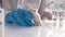 Close up shot of young female scientist in rubber gloves holding white laboratory rat and talking to her colleagues