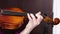 A close up shot of a young girl practices her violin in classroom