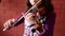 A close up shot of a young girl practices her violin in classroom