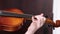 A close up shot of a young girl practices her violin in classroom