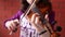 A close up shot of a young girl practices her violin in classroom