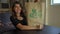 Close up shot of young woman calligrapher writing on a paper bag using lettering technique. She writes Go green on it