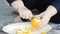 Close-up shot of a young woman hands with knife removing an orange skin