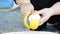 Close-up shot of a young woman hands with knife removing a tropical orange skin