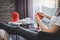 Close up shot of young woman hands knitting a red scarf handicraft in the living room on terrace at home