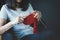 Close up shot of young woman hands knitting a red scarf handicraft in the living room on terrace at home