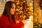 Close up shot of young woman igniting candles in decorated Christmas room