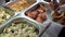 close-up showcase of buffet with different food options. The customer picks up the chicken on his plate.