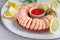 Close-up on shrimp ring with sweet chili sauce on marble serving board