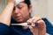 Close-up of sick woman presenting thermometer with high fever