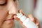 Close up of sick woman using nasal spray