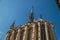 Close-up of side columns and towers of the gothic Sainte-Chapelle church under blue sky, in Paris.