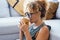 Close up side portrait of attractive blonde adult woman drinking coffee or tea at home alone smiling and enjoying the moment.