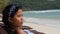 Close up side portrait view of a young Asian woman sitting on the beach bench.