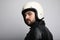 Close-up side portrait of young happy biker man with white cafe-racer helmet. White background.