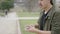 Close up side shot of a male magician shuffling with cards before doing tricks at daytime with the view of stone walls